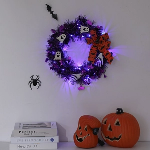 Halloween wreath with purple LED lights, black tinsel, white ghosts, and skeleton hands