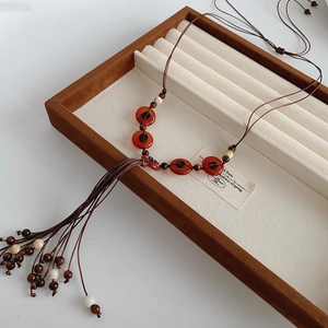 Close-up of Bohemian necklace with resin beads and intricate long fringe tassel detail