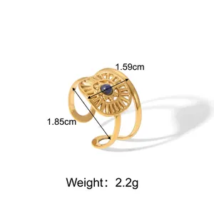 Detail of adjustable gold ring featuring a blue stone inlay and sunburst engraving