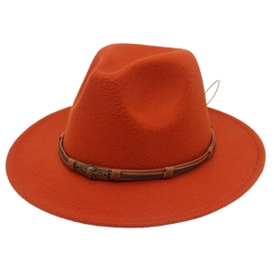 Detailed texture of orange felt fedora with braided leather band and skull badge