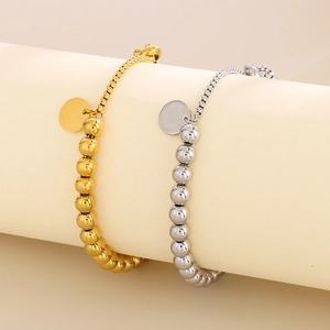 Détail de bracelets à billes en or 18 carats et argent avec pendentifs ronds