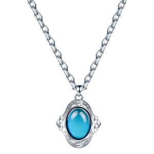 Vue macro d'un collier vintage en argent avec pierre d'humeur ovale bleue et texture gaufrée
