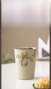 Detail of Ru Kiln ceramic cup featuring a cute hand-painted tabby cat and yellow flowers