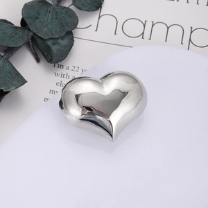 Dettaglio del ciondolo a cuore in argento lucido su un piedistallo bianco pulito