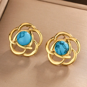 Macro shot of gold floral earrings with center turquoise stones and hollow petals