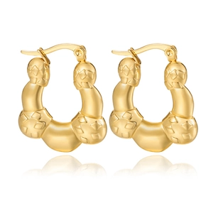 Detailed view of golden hoop earrings with embossed diamond-pattern woven texture