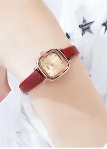 Close-up of vintage square quartz watch with rose gold case and red leather strap