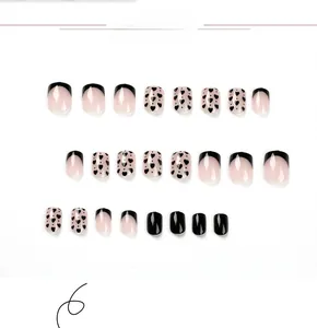 Detail of 24pcs short square press-on nails with black french tips and heart patterns