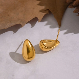 Elegant gold-tone geometric teardrop stud earrings displayed on a white marble background