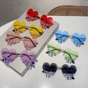 Close-up of seven heart-shaped rimless sunglasses with dangling crystal rhinestone tears