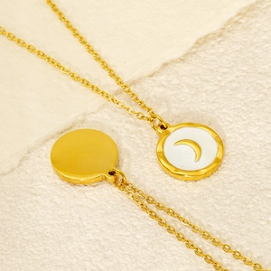 Gros plan détaillé du collier en acier doré avec pendentif lune et incrustation blanche