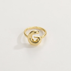 Macro view of adjustable 18K gold letter G ring with a polished metallic finish