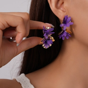 Elegant purple fabric flower C-shaped earrings with gold metal accents worn by model