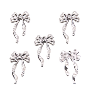 Macro view of five silver alloy bow pendants showing front and textured back details