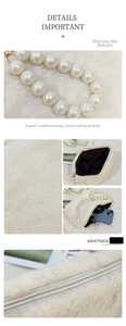 Detail of plush cream handbag featuring faux pearl handle and smooth silver zipper closure