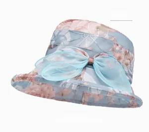 Detail of the light blue summer sun hat with floral print and organza bow decoration