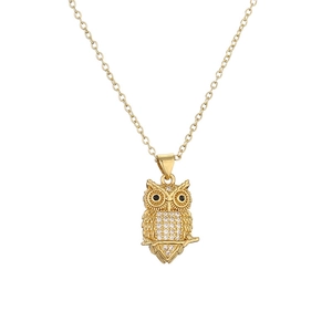 Gold owl pendant necklace with white crystals and black gem eyes on a white background