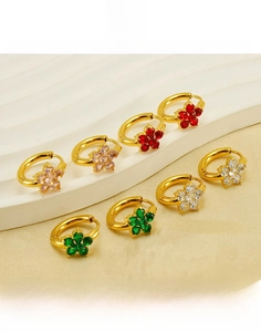 Gros plan détaillé de créoles en acier titane doré 18 carats avec fleurs en zircon