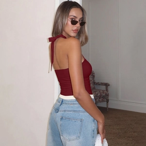 Detail view of burgundy halter neck top with open back design and ribbed knit texture