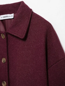 Detailed close-up of burgundy wool coat collar and brown buttons with high texture