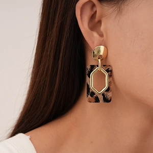 Detailed close-up of a model wearing retro leopard print rectangle earrings with gold studs