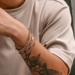 Men's silver titanium bamboo Cuban chain bracelet set shown on a tattooed model wrist
