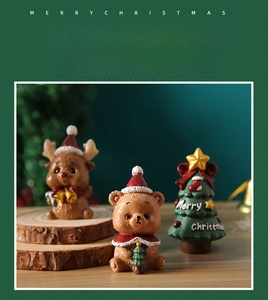 Close-up of festive reindeer, bear, and Christmas tree figurines on a wooden base