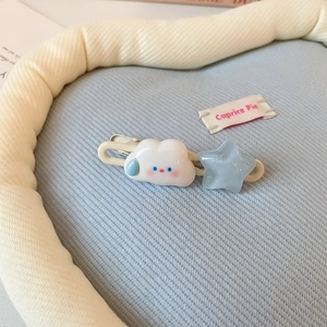 Gros plan d'une jolie pince à cheveux en résine avec nuage et étoile bleue sur tissu