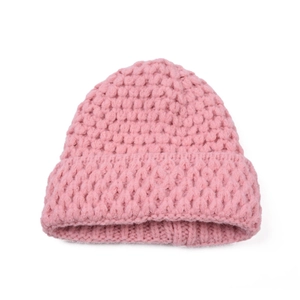 Close-up of pink knitted baby beanie with thick textured yarn and folded brim design