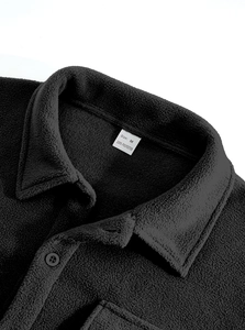 Macro detail of black fleece shirt jacket collar with Size M wash label and buttons