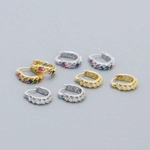Macro detail of 925 silver huggie earrings with gold finish and colorful zircons