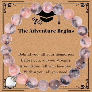 Detail of pink and grey natural stone beaded bracelet with silver heart pendant on card