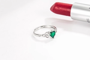 Detailed view of silver heart ring featuring a vibrant green emerald-cut zircon stone