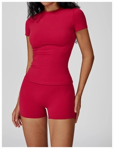 Detail of high-stretch quick-dry yoga set with short-sleeve top and high-waist shorts in deep red