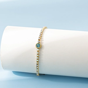 Détail macro du bracelet en acier inoxydable 18K avec zircon bleu et accents colorés