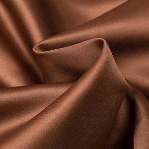 Detailed close-up of smooth brown satin fabric showing elegant draped texture and sheen