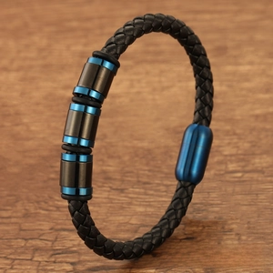 Macro view of men's braided leather bracelet with blue magnetic clasp and metal beads