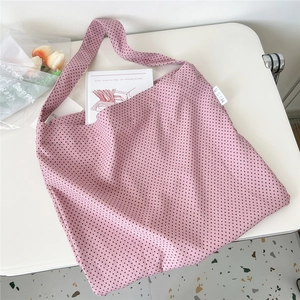 Detailed close-up of pink canvas tote bag featuring black heart prints and MISS woven label