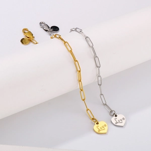 Gold and silver heart pendant chain bracelets with Love engraving on a white display