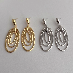 Minimalist interlocking triple oval hoop earrings in polished gold and silver metal finishes