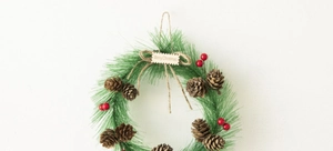 Close-up of Christmas wreath with pine needles, cones, berries and Merry Christmas sign