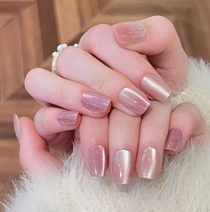 Detailed view of pink cat-eye press-on nails with shimmering pearlescent finish and gloss