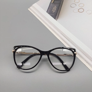 Detailed top view of black and gold cat-eye glasses frame on a stylish magazine