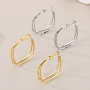 Detailaufnahme zweilagiger geometrischer Creolen in 18K Gold und Silberoptik