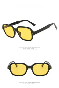 Macro detail of square thick-framed sunglasses with yellow lenses and metal studs