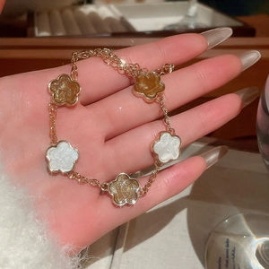 Détail du bracelet fleuri de style vintage français avec chaîne dorée et pendentifs