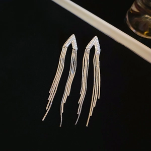 Détail de boucles d'oreilles pampilles argentées avec forme en V et cristaux brillants