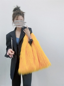 Detailed texture of the large bright yellow faux fur tote bag in Y2K style on a model