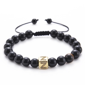 Detail of tiger eye bead and zircon Z letter block on black onyx stone bracelet