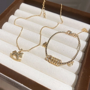 Makroansicht von 18 Karat vergoldeter Pferdeanhänger-Halskette und Armband-Set